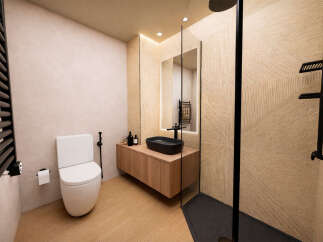 Step into a modern bathroom oasis! This beautifully designed space features a sleek black sink atop a wooden vanity, complemented by stylish geometric wall tiles.