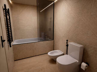 This modern bathroom features a sleek design with a bathtub, toilet, and bidet.