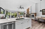 Experience modern living in this stunning open-concept home, featuring a sleek kitchen island with a double sink and stainless steel dishwasher.