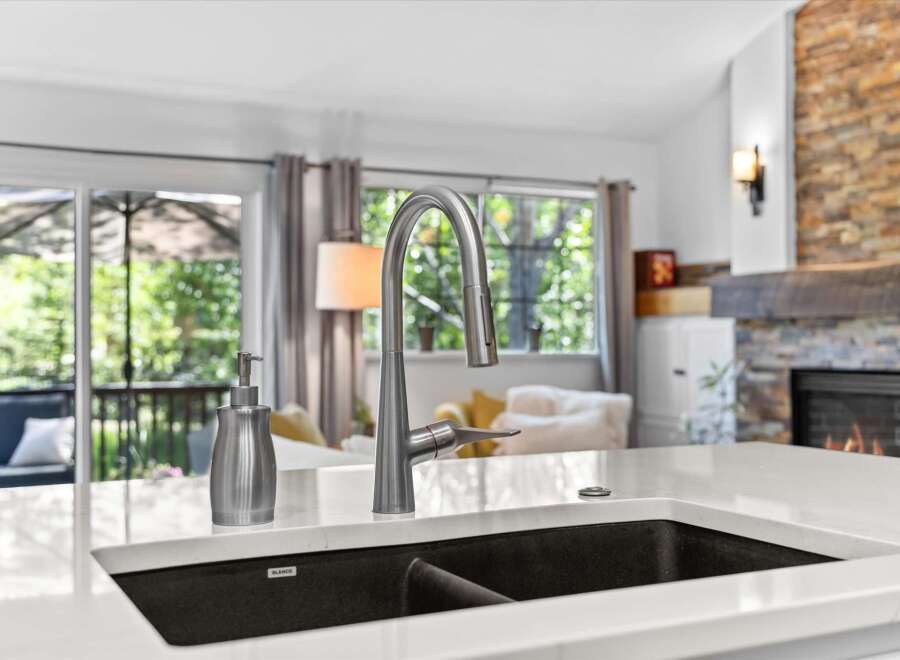 Experience modern living with this stunning kitchen featuring a sleek stainless steel faucet and a deep undermount sink.