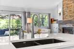 Experience modern living with this stunning kitchen featuring a sleek stainless steel faucet and a deep undermount sink.