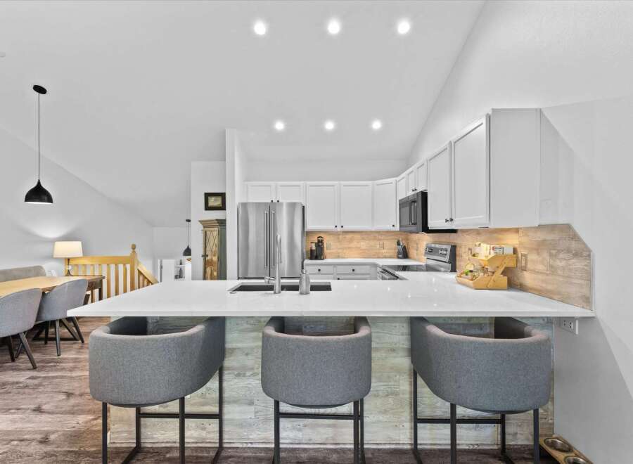Experience modern living in this stunning kitchen featuring sleek white cabinetry and a spacious quartz island perfect for entertaining.