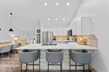 Experience modern living in this stunning kitchen featuring sleek white cabinetry and a spacious quartz island perfect for entertaining.