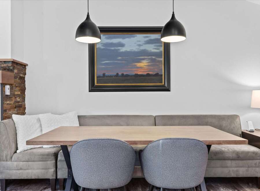 Enjoy cozy meals in this charming dining area featuring a comfortable banquette seating arrangement.