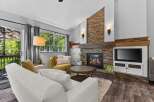 Cozy living room featuring a stunning floor-to-ceiling stacked stone fireplace with a rustic wood mantel.