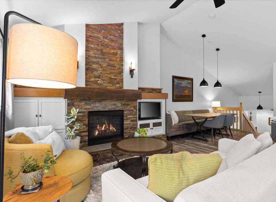 Experience cozy living in this inviting living room, featuring a stunning stacked stone fireplace as the centerpiece.