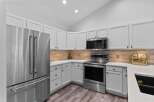 This modern kitchen boasts sleek stainless steel appliances, including a French door refrigerator and a built-in microwave.