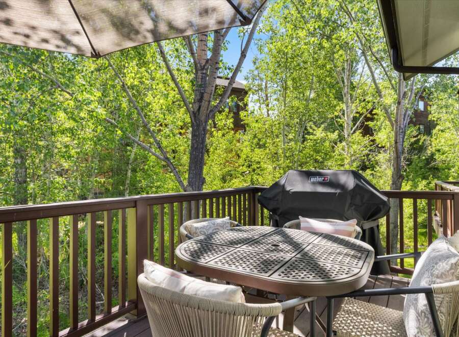 Enjoy outdoor living on this charming deck, perfect for entertaining or relaxing amidst lush greenery.