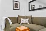 Cozy up in this inviting living space featuring a comfortable sectional sofa adorned with decorative pillows and a plush throw blanket.