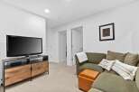 This inviting living space features a large flat-screen TV mounted above a stylish wooden media console, perfect for entertainment.