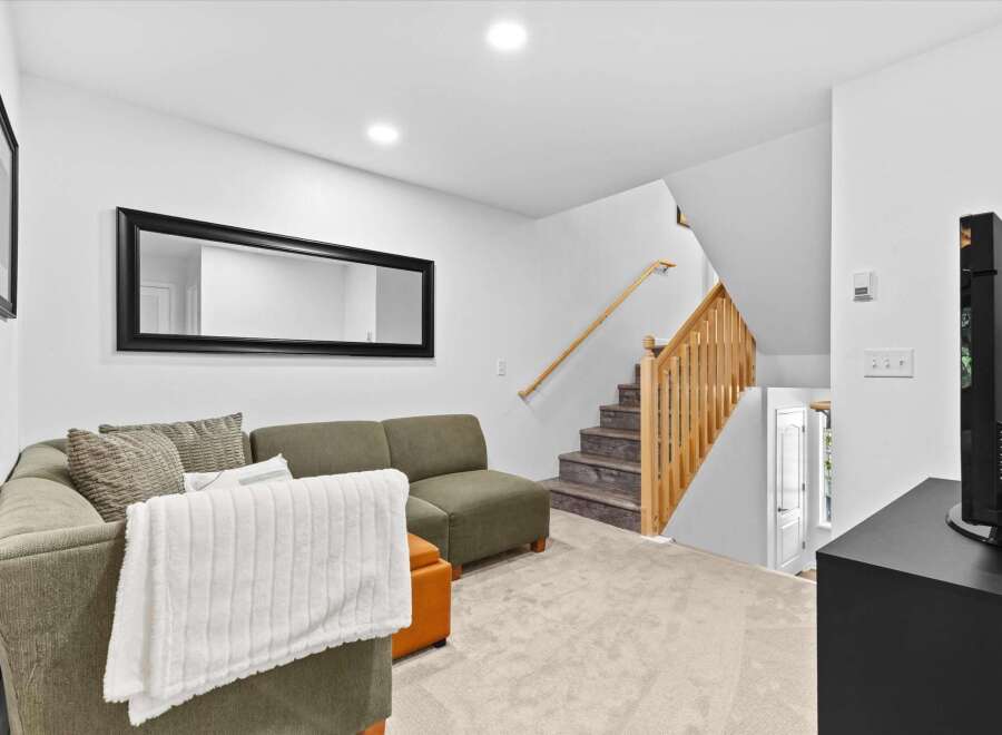 This inviting living space features a comfortable sectional sofa adorned with plush pillows and a cozy throw blanket, perfect for relaxation.