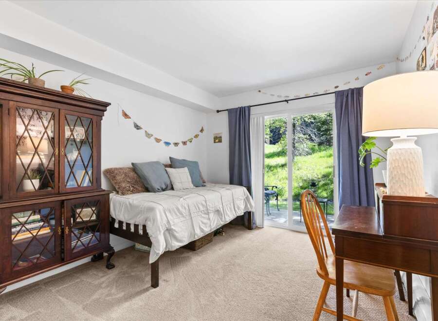 This charming bedroom features a cozy daybed perfect for relaxation, complemented by a beautiful antique china cabinet for storage and display.