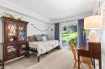 This charming bedroom features a cozy daybed perfect for relaxation, complemented by a beautiful antique china cabinet for storage and display.