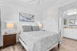Discover comfort and style in this inviting bedroom, featuring a plush queen-size bed adorned with a charming floral-patterned comforter and coordinating gray pillows.