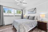 Experience comfort and style in this beautifully appointed bedroom, featuring a plush queen-size bed adorned with a charming floral-patterned quilt and coordinating grey pillows.