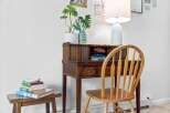 Discover a charming workspace featuring a vintage wooden secretary desk adorned with a potted plant and decorative items.
