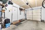 This spacious garage offers ample storage solutions, including overhead shelving and wall-mounted racks perfect for organizing sports equipment like skis and helmets.