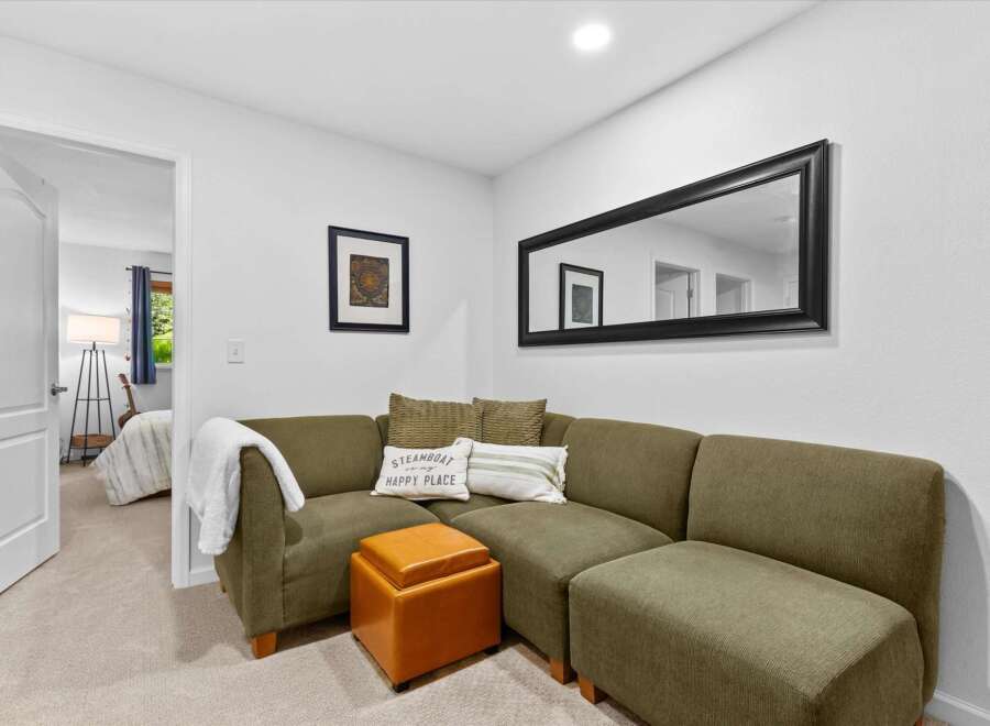 Step into this inviting living space featuring a comfortable sectional sofa adorned with decorative pillows, perfect for relaxing.