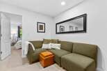 Step into this inviting living space featuring a comfortable sectional sofa adorned with decorative pillows, perfect for relaxing.