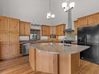 This stunning kitchen boasts custom cabinetry, a large island with granite countertops, and stainless steel appliances.