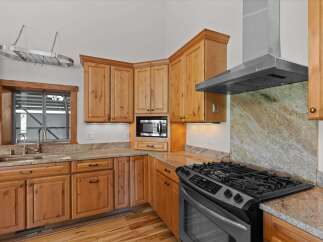 This stunning kitchen boasts custom cabinetry and granite countertops, creating a warm and inviting atmosphere.