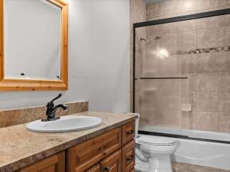 This bathroom features a stylish vanity with a sink and a beautiful wooden mirror.