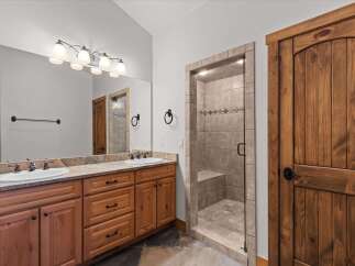 Step into luxury with this beautifully designed bathroom! Featuring a spacious vanity with dual sinks, a walk-in shower, and elegant wooden accents throughout.