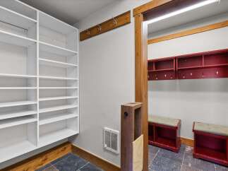 Step into organized living with this stunning entryway! Featuring custom built-in shelving, a coat rack, and a mudroom with benches, this space is designed for both style and functionality.