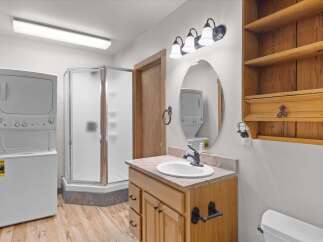 Step into this inviting bathroom featuring a convenient stacked washer and dryer, perfect for modern living.