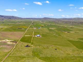 Discover a stunning rural property with vast green fields and a picturesque landscape.