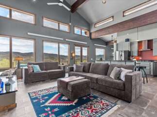 Experience luxury living in this stunning property! This home features a spacious living area with high ceilings, large windows, and a modern kitchen.