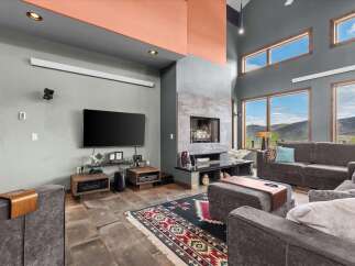 Discover luxury living in this stunning property featuring a modern fireplace and expansive windows that frame breathtaking mountain views.