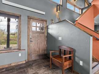 Step into this inviting entryway, showcasing a rustic wooden door and trim that exudes warmth and character.