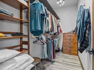 Step into this well-organized walk-in closet, offering ample storage space for your wardrobe.
