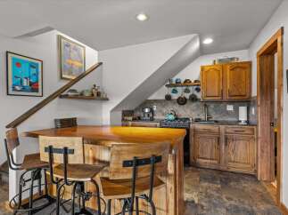 This charming kitchen features a unique design with a wooden bar and stylish bar stools, perfect for entertaining.