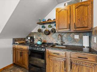 This charming kitchen features beautiful wooden cabinetry and a stylish tile backsplash, creating a warm and inviting atmosphere.