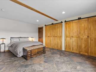 Step into this inviting bedroom featuring a blend of rustic charm and modern design.