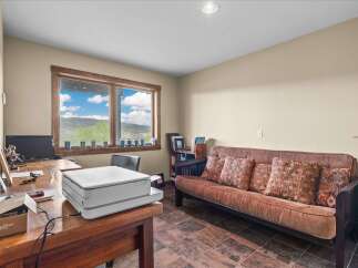 This inviting home office features a stunning view through a large window, perfect for inspiring productivity.