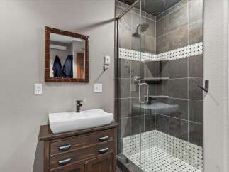 This stunning bathroom features a modern design with a sleek vanity and a glass-enclosed shower.