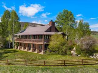 This stunning property features a beautiful two-story house with a rustic design, perfect for those seeking a tranquil retreat.