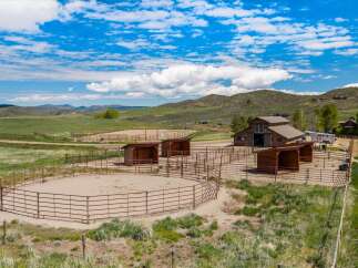 Discover your dream equestrian estate! This stunning property features a spacious riding arena, multiple horse shelters, and a well-maintained barn.