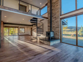 Step into luxury with this stunning property featuring a modern spiral staircase and expansive windows that flood the space with natural light.