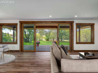 Step into luxury with this stunning property, featuring expansive windows that frame breathtaking views of the lush green landscape.