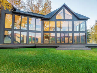 This stunning modern home boasts expansive windows that flood the interior with natural light, offering breathtaking views of the surrounding landscape.