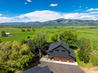 Experience luxury mountain living in this stunning modern farmhouse estate, nestled amidst sprawling green fields and majestic mountain vistas.