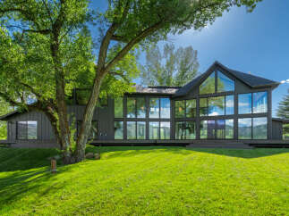 Experience modern luxury in this stunning home featuring expansive floor-to-ceiling windows that flood the interior with natural light and offer breathtaking views of the surrounding landscape.