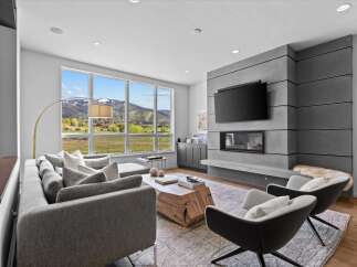 Experience luxury living in this stunning property, featuring a modern living room with breathtaking mountain views.