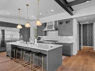 This stunning kitchen boasts a modern design with sleek gray cabinetry and a spacious island, perfect for both cooking and entertaining.