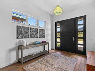 Step into luxury with this stunning entryway! Featuring a modern black door, a stylish console table, and beautiful artwork, this space is designed to impress.