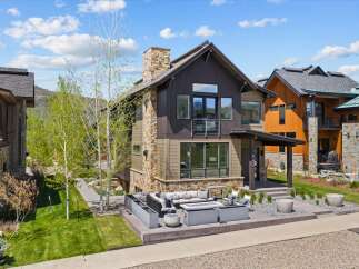 This stunning modern home boasts a beautiful exterior with a combination of stone and wood siding.